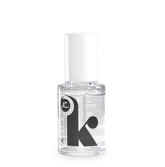 Clear nail polish bottle with JC Kind logo on a white background